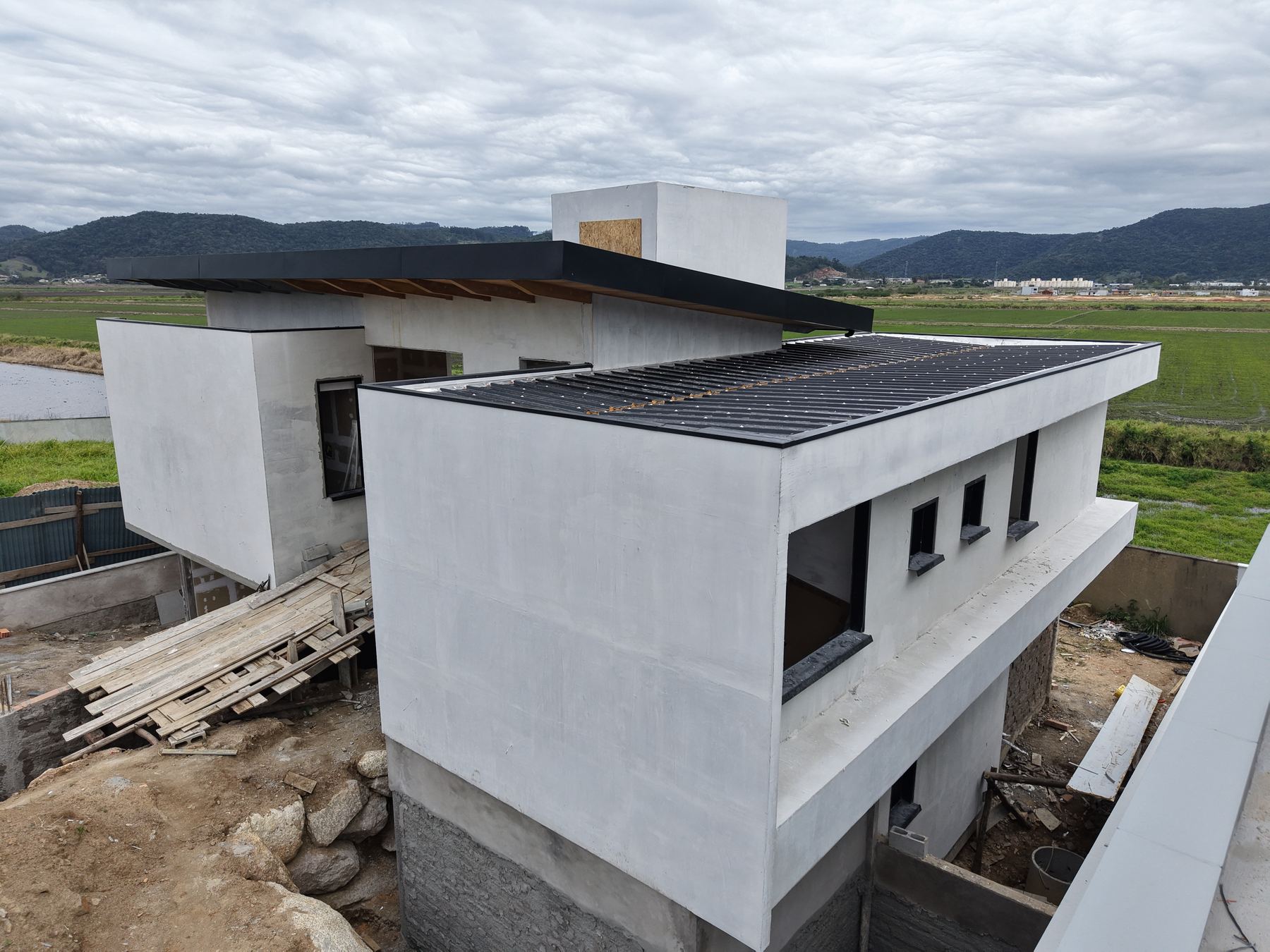Segunda vista aérea da Casa Mirante, com campos e montanhas ao fundo